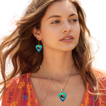 GRF – Ocean Flight jewelry set on model featuring teal glossy guitar pick design with the Golden Road Festival bird and Steal Your Face artwork.