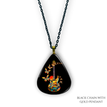 Close-up of handcrafted GRF Stella’s Flight necklace showing the vibrant Golden Road Festival butterfly-and-guitar artwork under a glossy epoxy finish.
