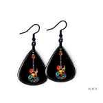 Close-up of Stella’s Jam earrings showing glossy black guitar pick design with vivid guitar art.