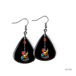 Close-up of Stella’s Jam earrings showing glossy black guitar pick design with vivid guitar art.