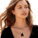GRF – Stella’s Jam jewelry set on model featuring the Golden Road Festival colorful guitar artwork with gold hooks and chain.