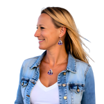Woman wearing a denim jacket with purple Slightly Stoopid earrings and necklace on a white background